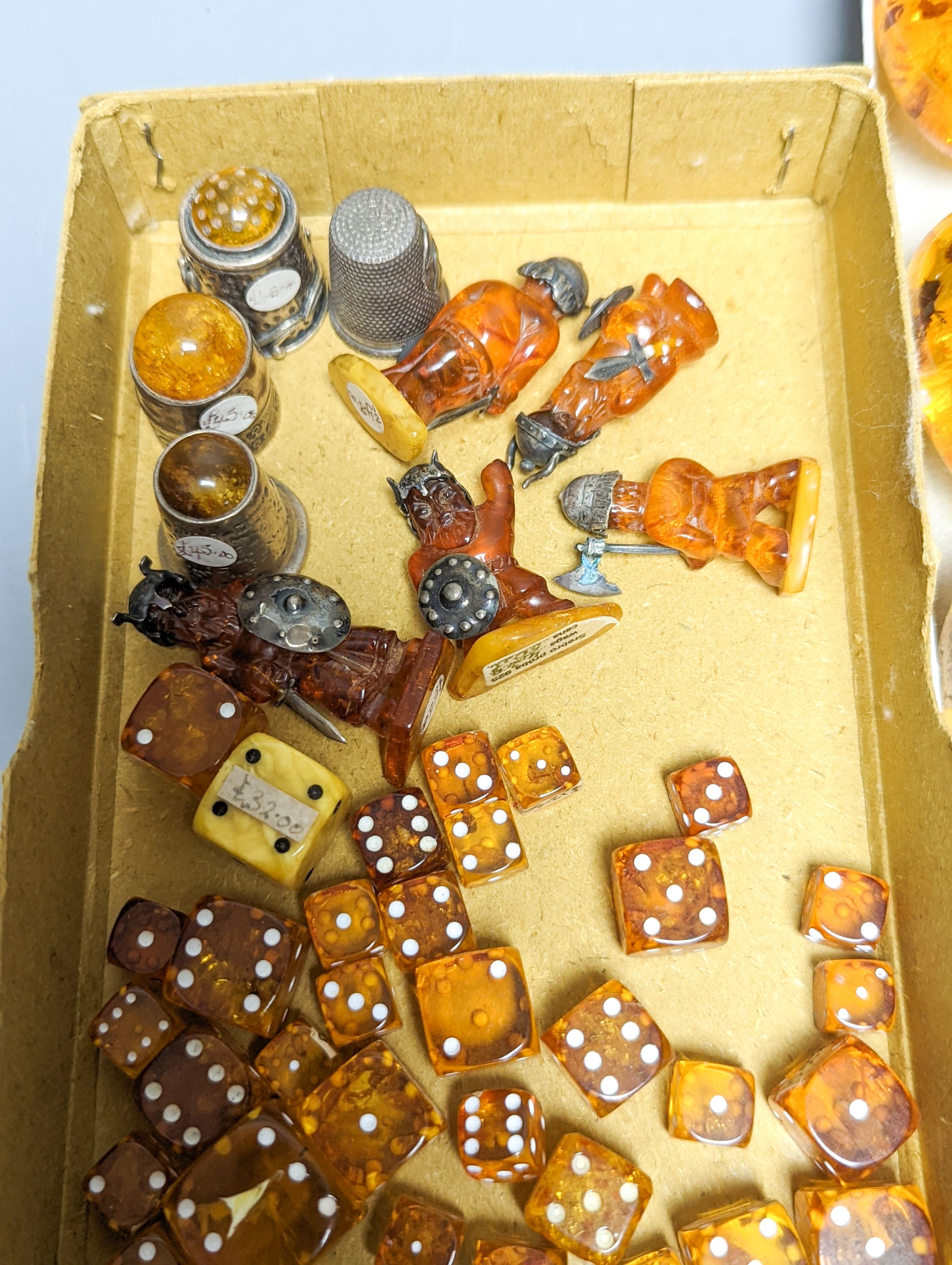 A mixed collection small carved amber wares including dice, eggs and cigarette holders, etc.